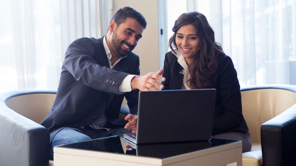 business couple looking at computer presentation