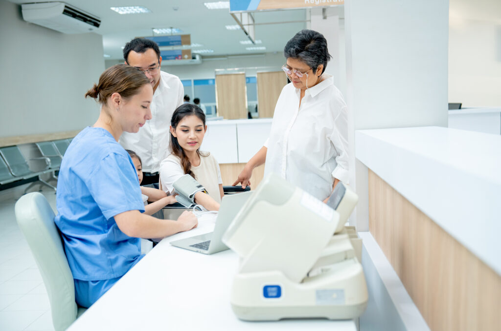 Caucasian nurse measure blood pressure of Asian woman and support by her family with husband