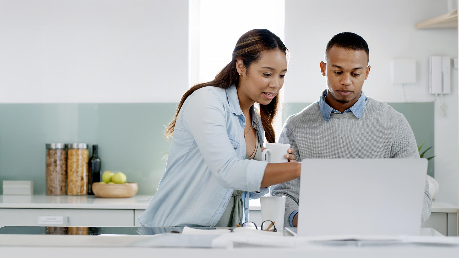 Couple, laptop and pointing in home for planning, travel discussion and online shopping.