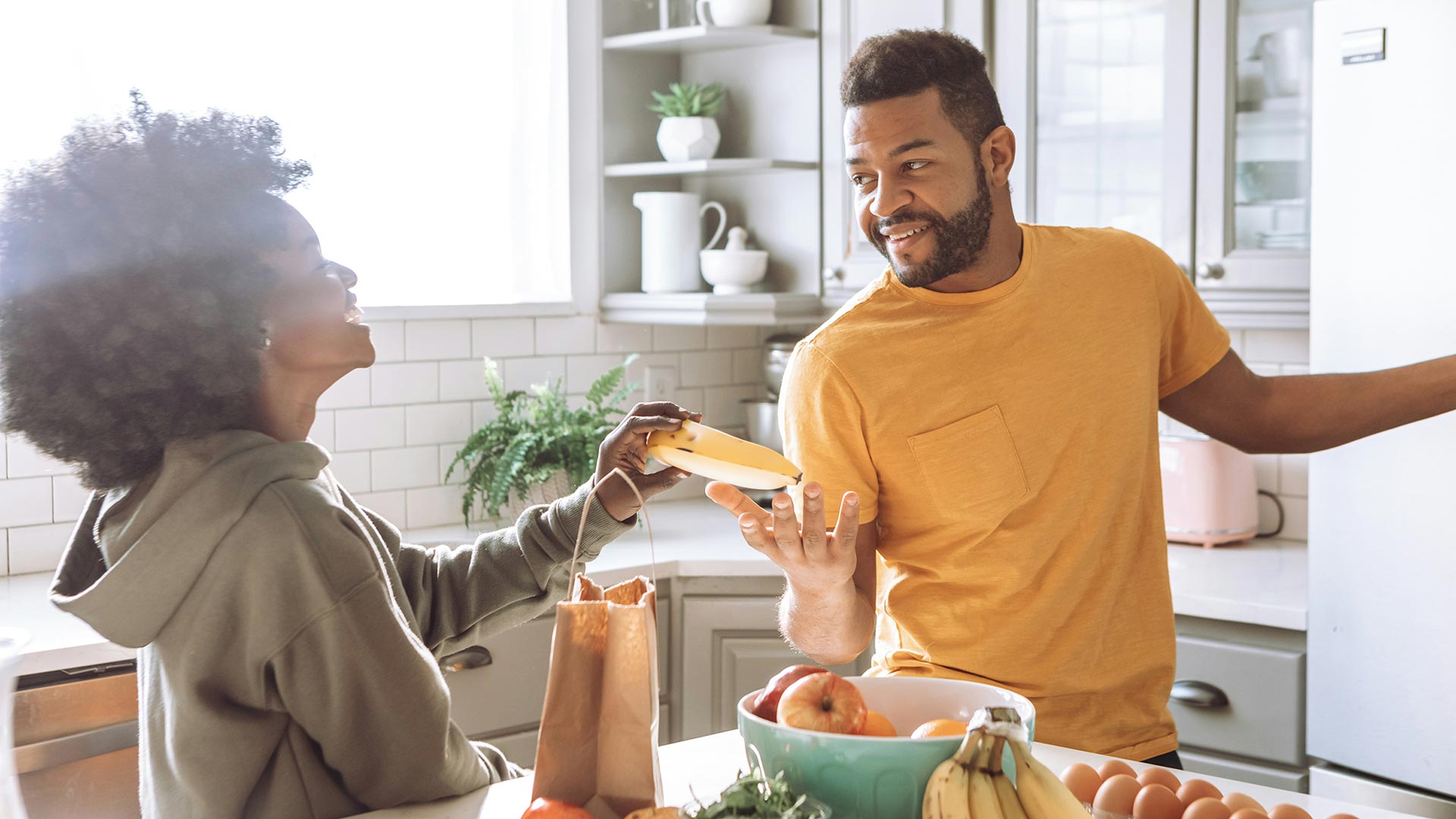 Couple putting groceries away at home