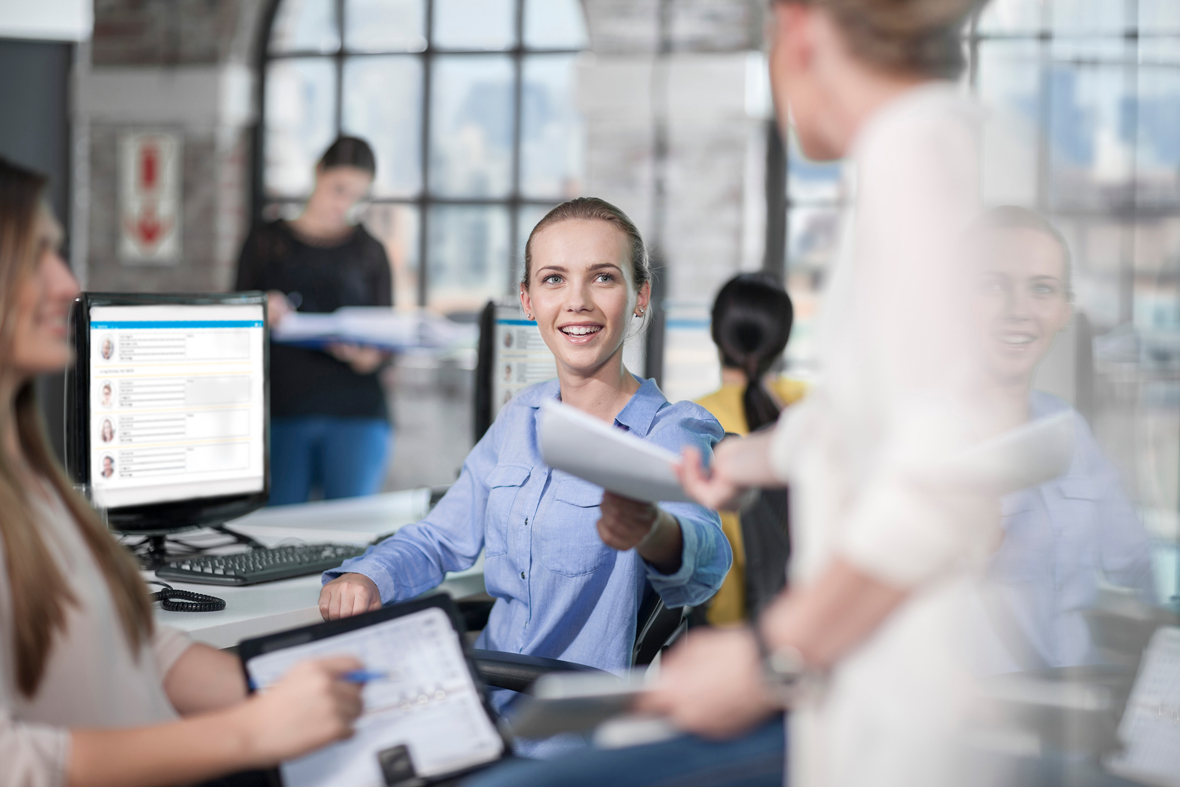Female manager handing out paperwork in office