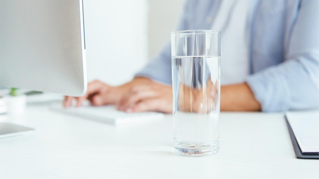 Glass of fresh water sitting on desk