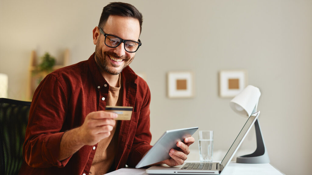 Handsome man makes online payment via his digital tablet