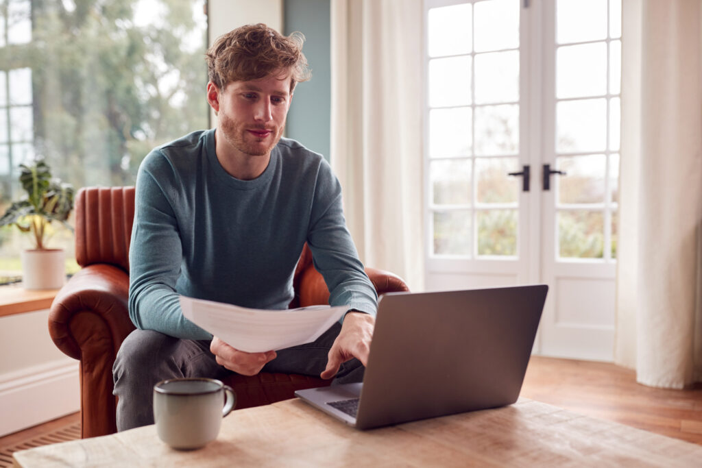 Man at home paying bills online