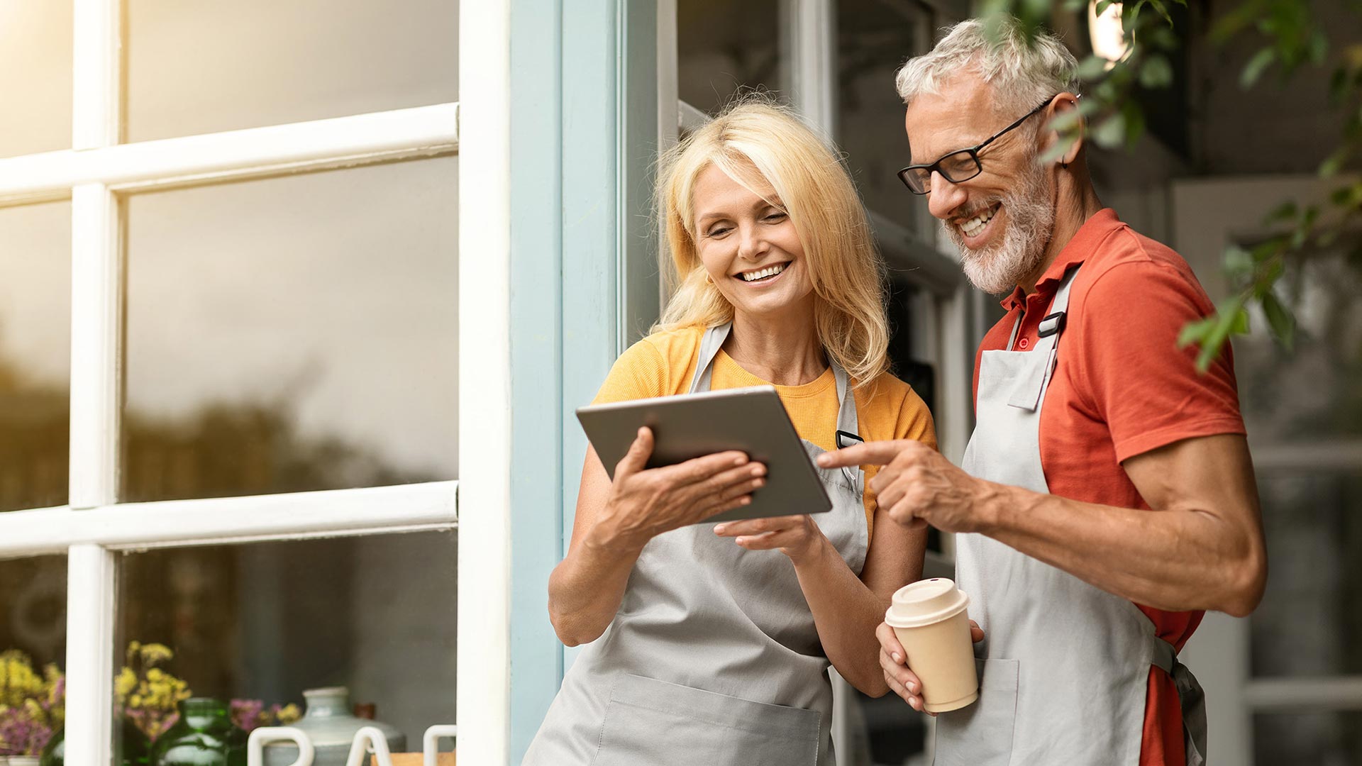 Mature smiling couple outside small business