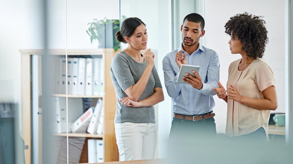 office colleagues having a discussion over a digital tablet