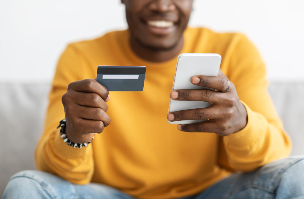 African guy holding cellphone and credit card