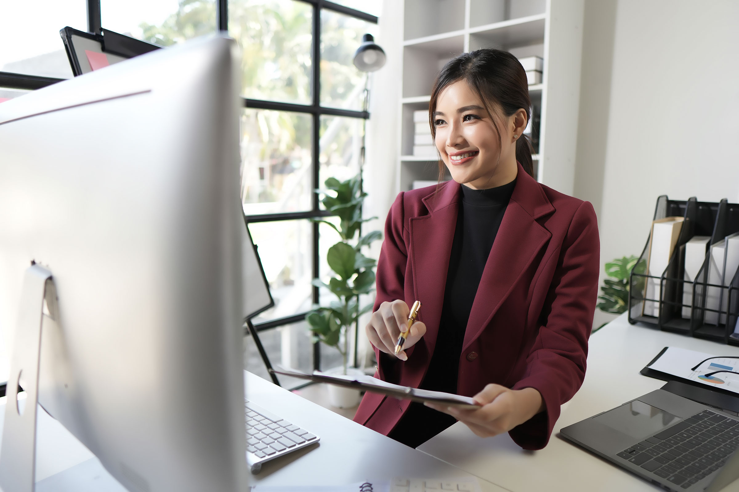 Woman making notes during an online business meeting