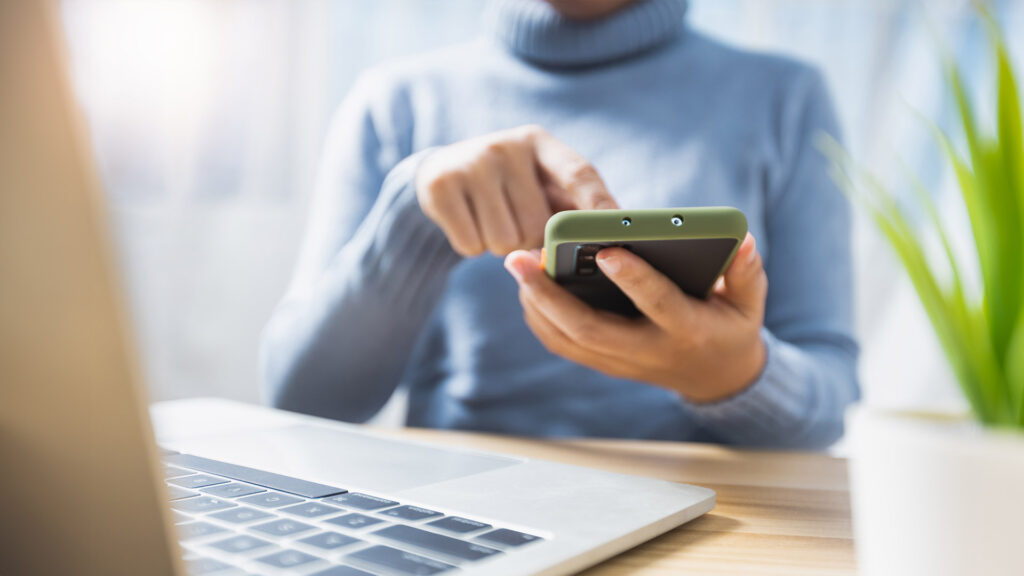 Woman's hands using phone to make mobile payment