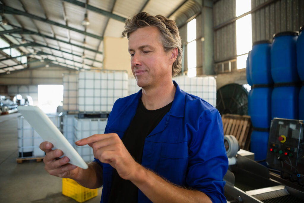 Worker using digital tablet in factory