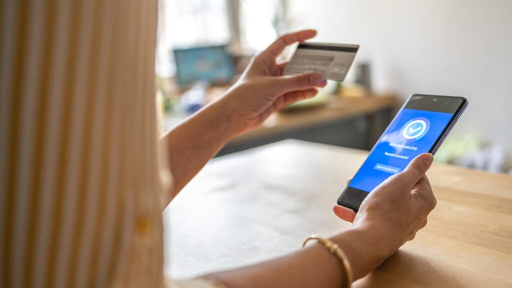 Young woman Paying Bills with mobile phone